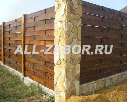 Плетеный деревянный забор с каменными столбами